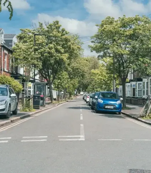 T junction looking down street with parked cars and trees