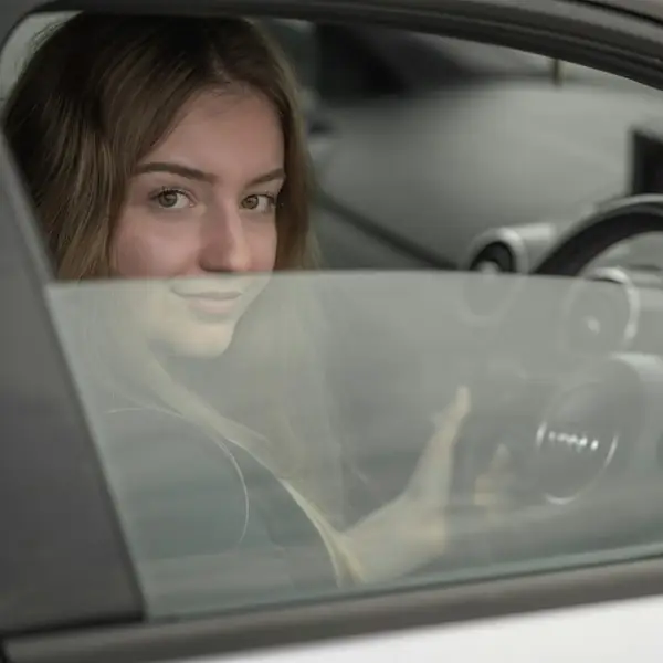 woman in driver seat of car looking at the camera